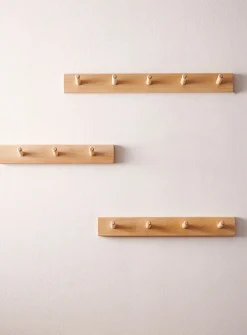 Wall-mounted dowel coat rack
