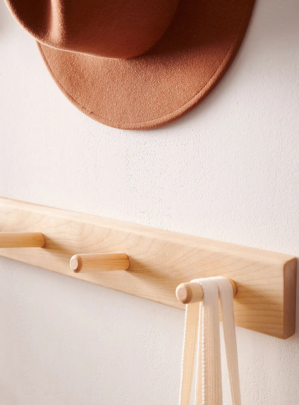 Wall-mounted dowel coat rack